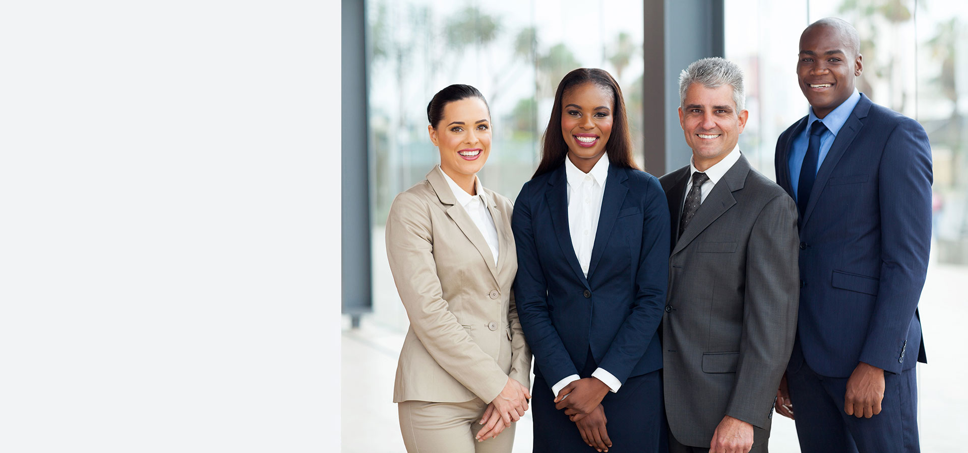 Image of two businesswomen and two businessmen standing and happy